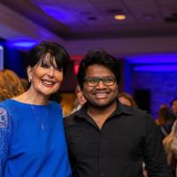 A grad smiles next to President Mantella